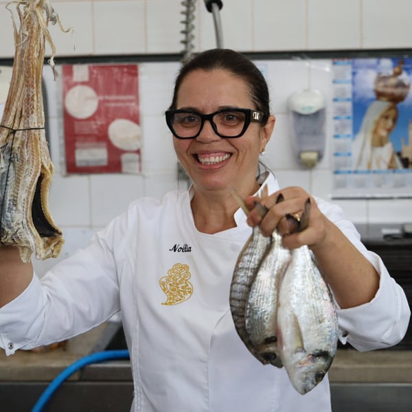 Uma chefe a mostrar peixe fresco num mercado.