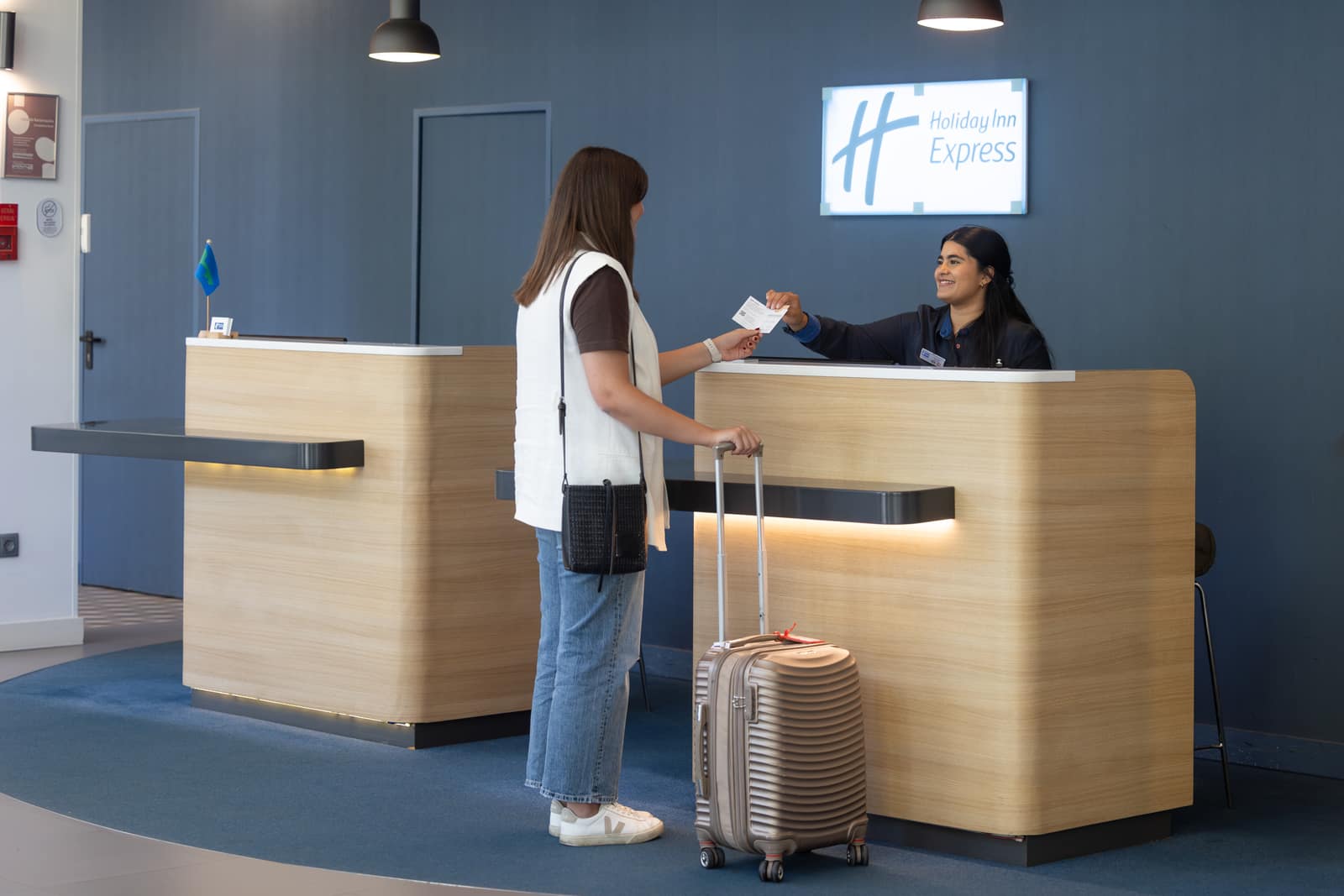 Uma hóspede a fazer check-in na receção de um Holiday Inn Express.